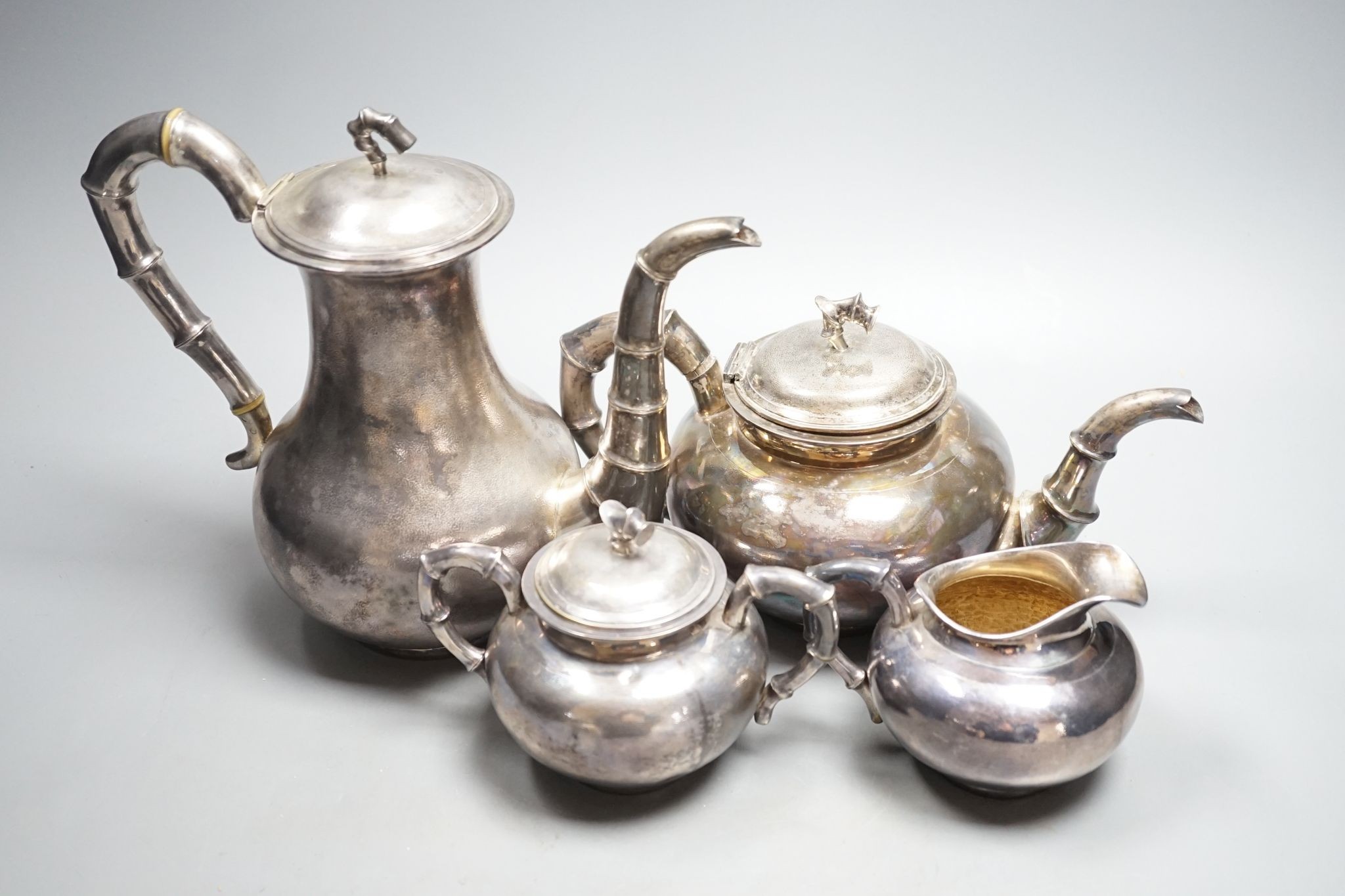 An early 20th century Chinese Export planished white metal four piece tea and coffee set, with faux bamboo handles, by Zee Wo, gross 44oz.